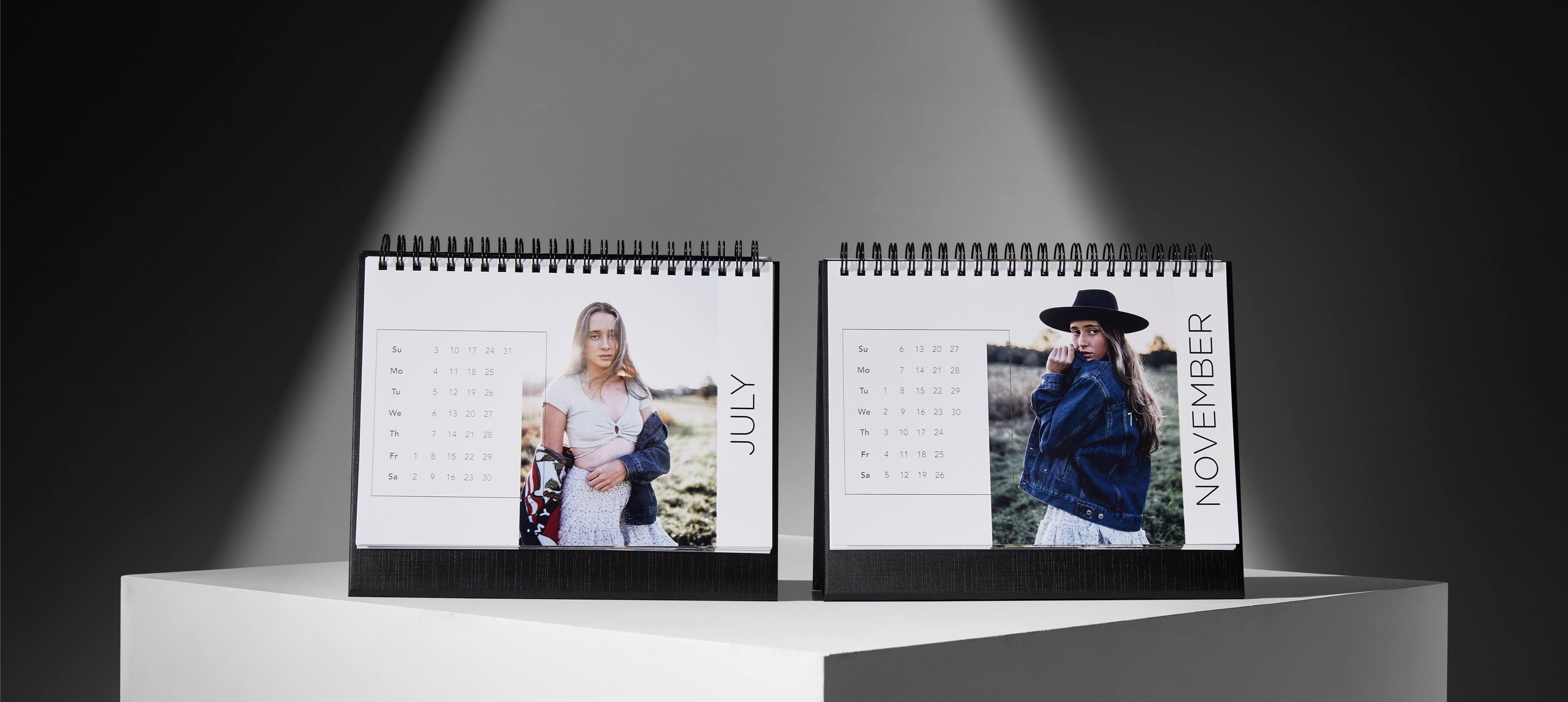 two desk calendars on a white table showing a woman in denim jacket