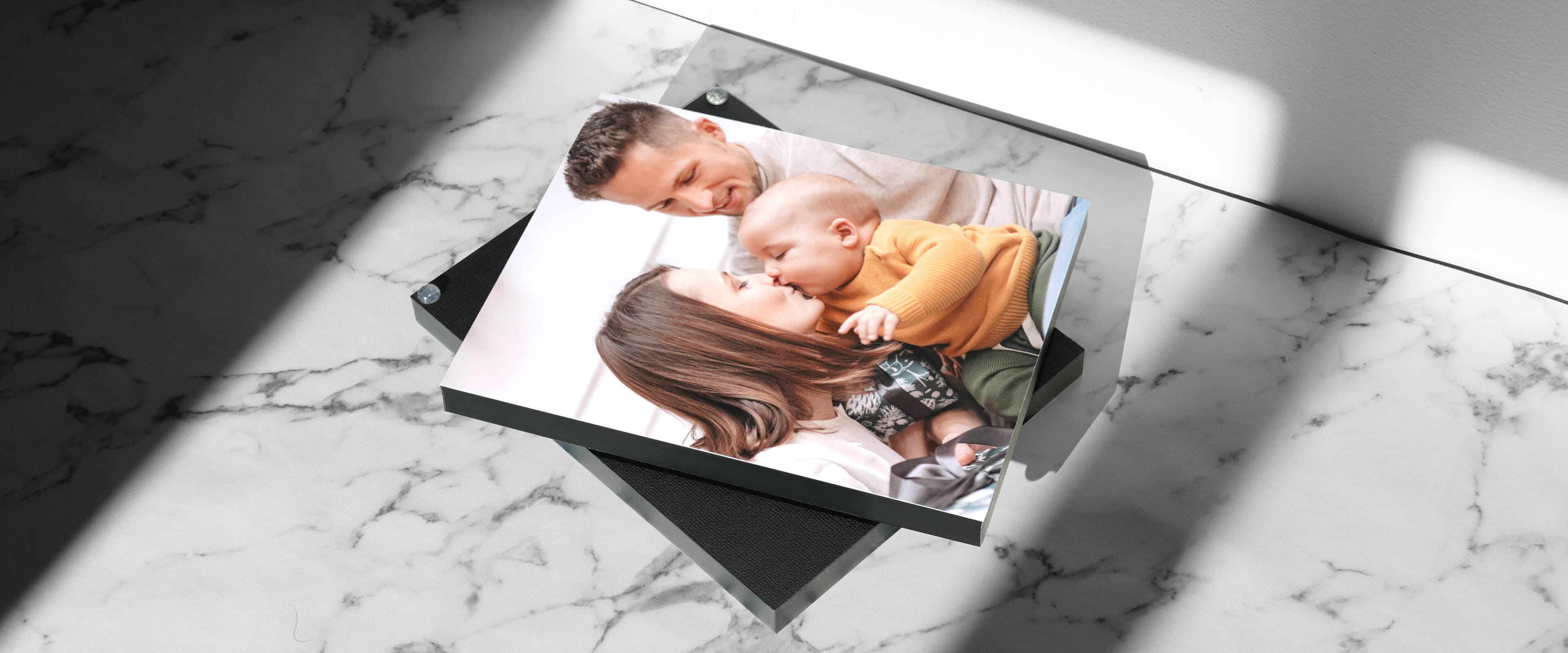 two standout mounted prints on a marble background with photo of family