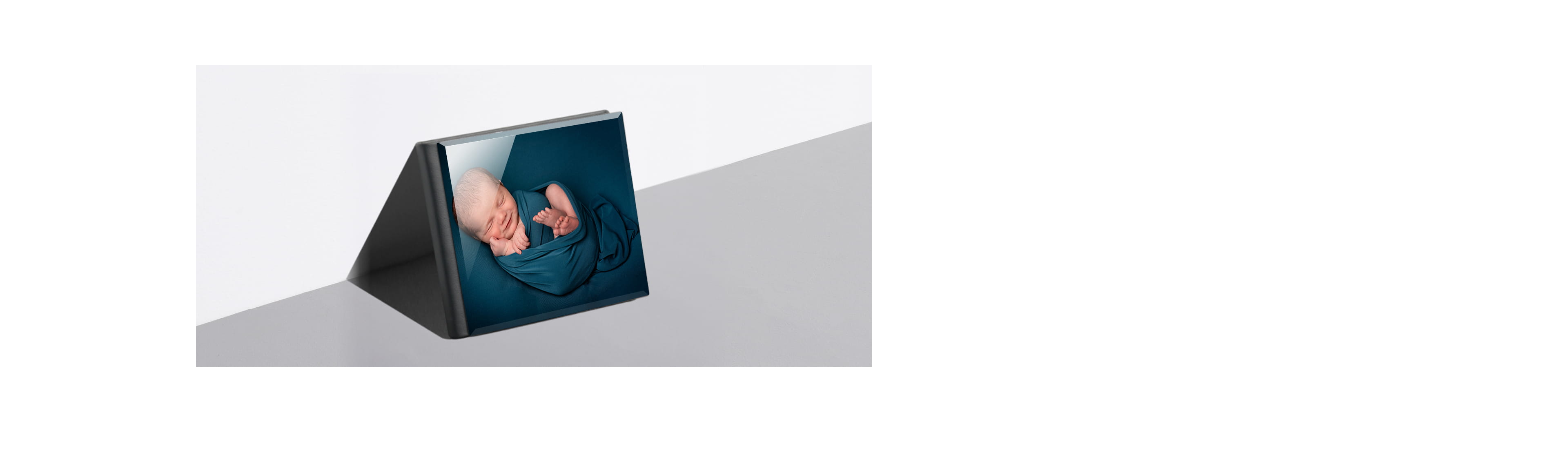 newborn album leaning against a wall with a baby on cover