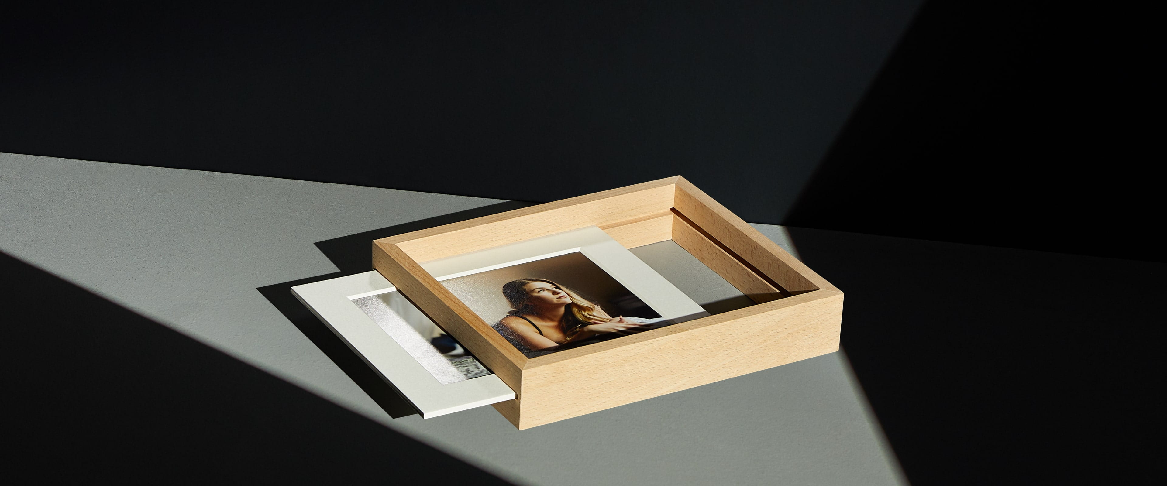 a slide-in print stand on white table showing a matted print sliding out